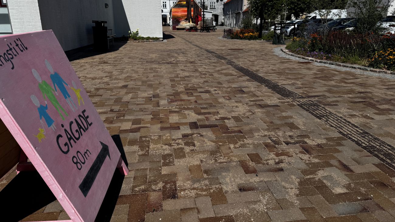 Lyserøde skilte viser vej til gågaden